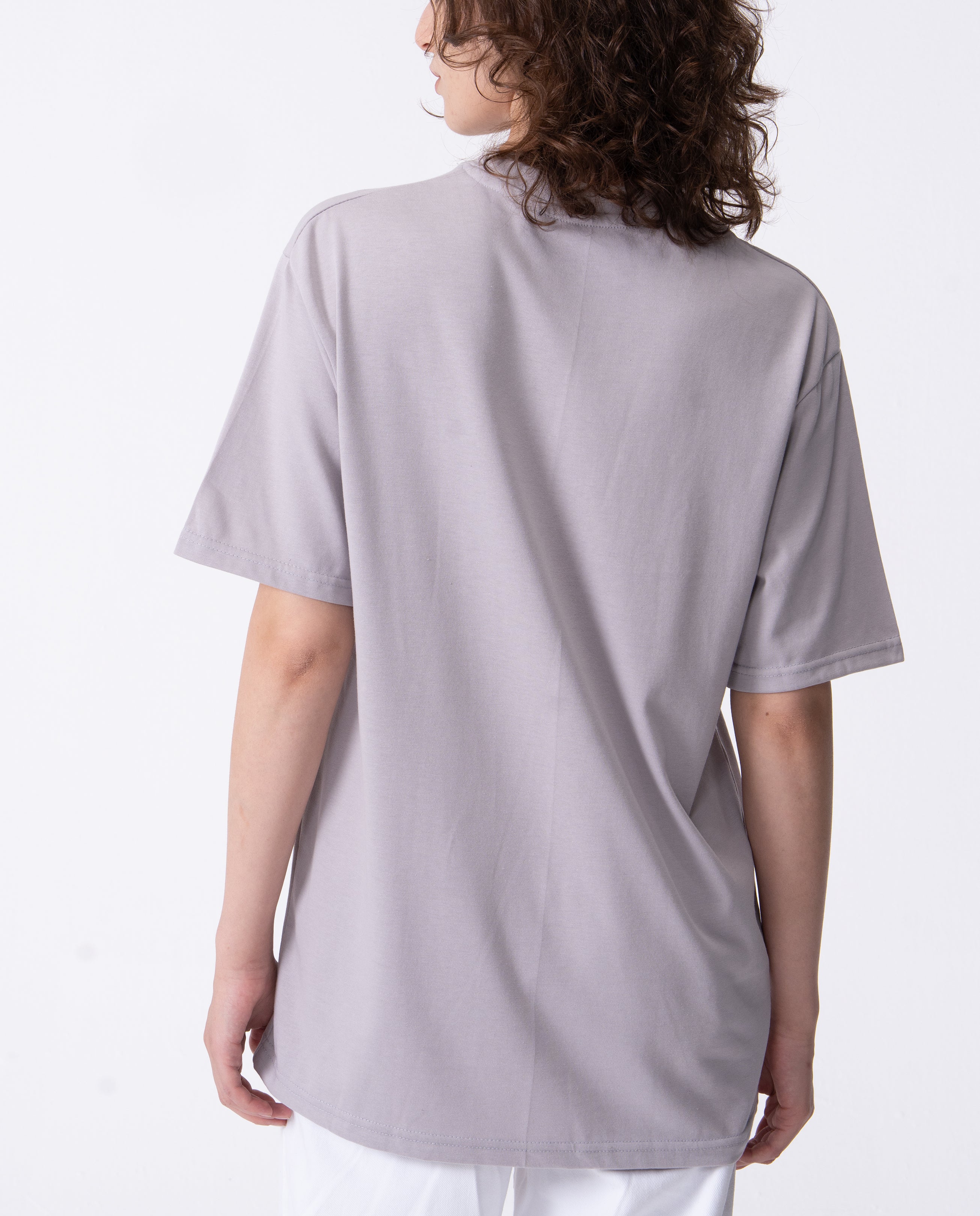 Person wearing a light gray t-shirt on a white background