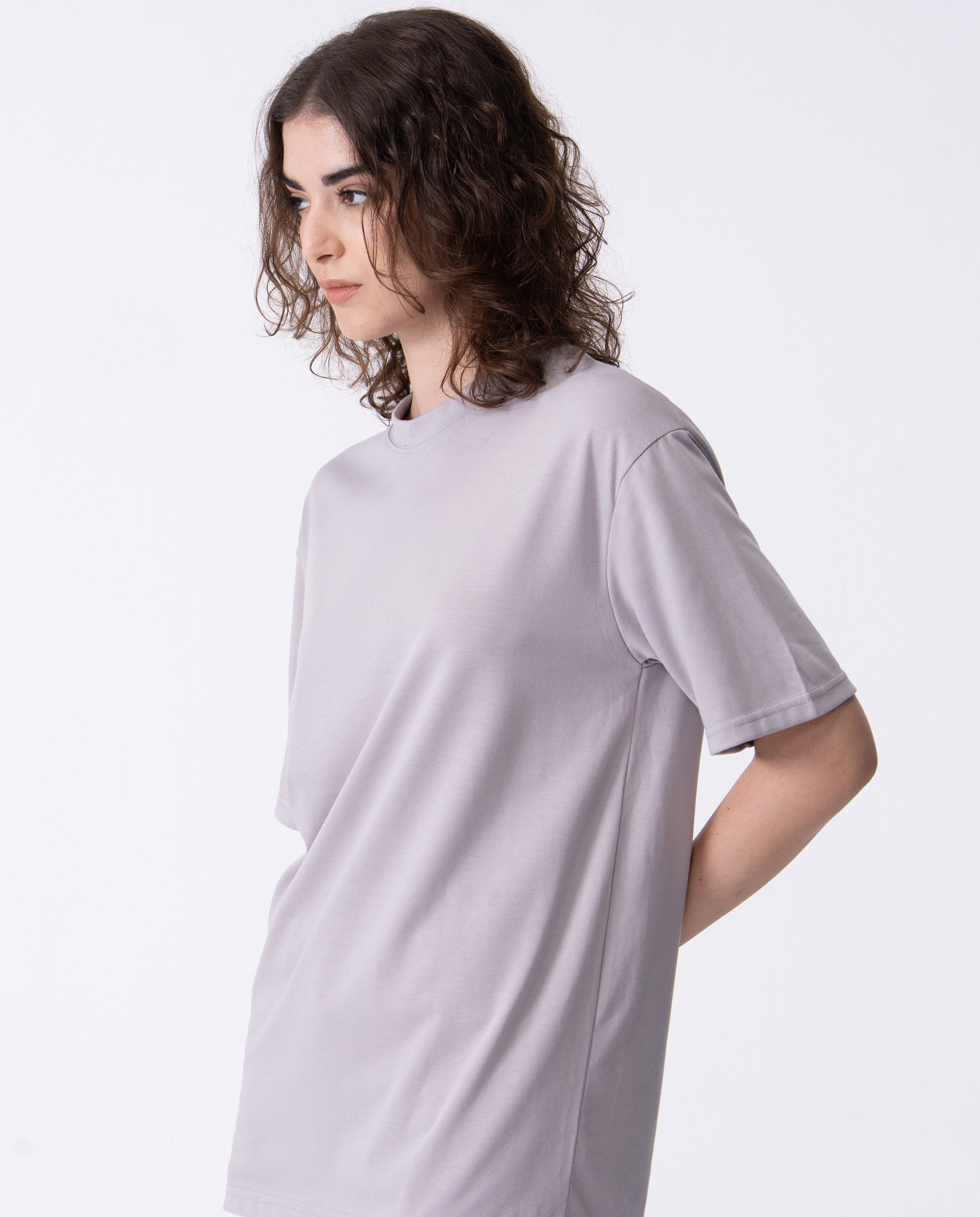 Person wearing a light gray t-shirt against a white background