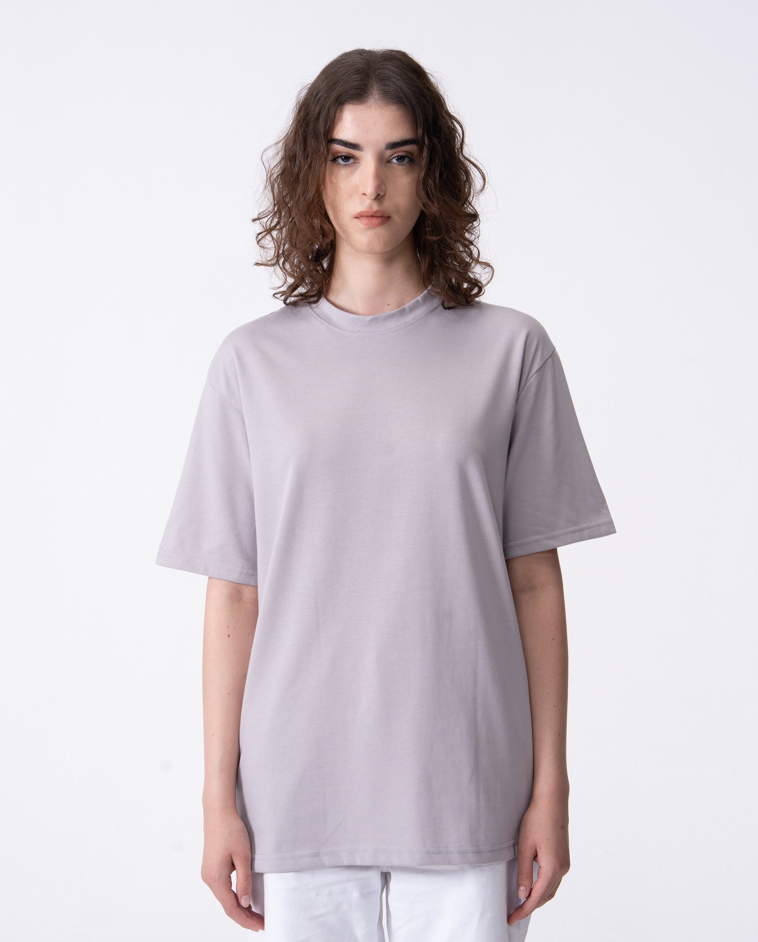 Person wearing a plain light gray t-shirt on a white background