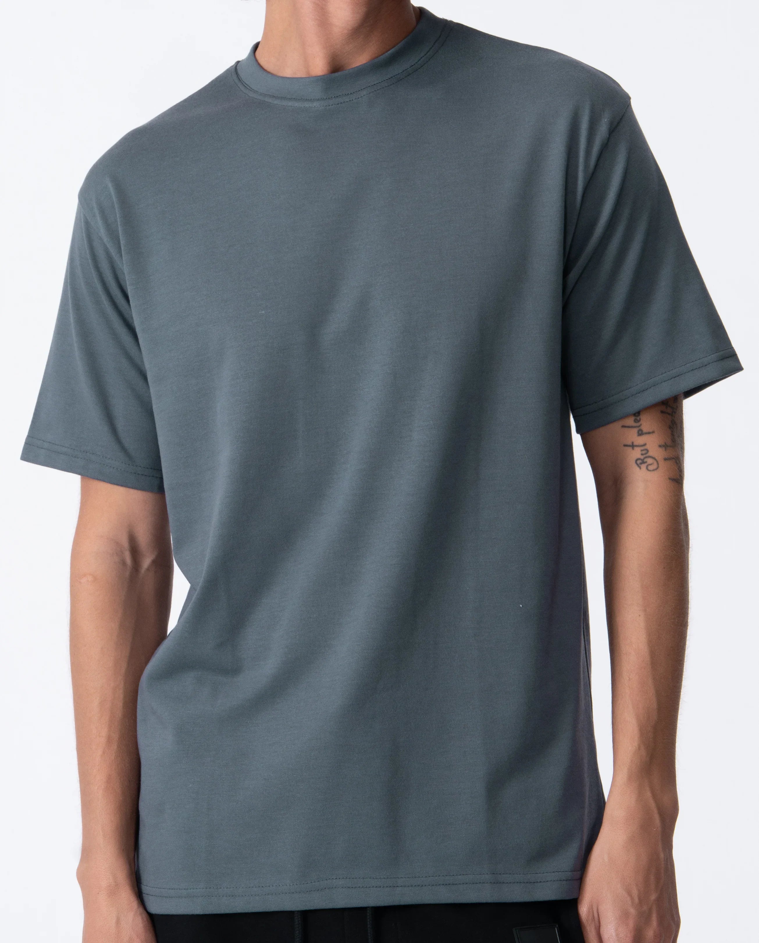 Person wearing a plain gray t-shirt on a white background