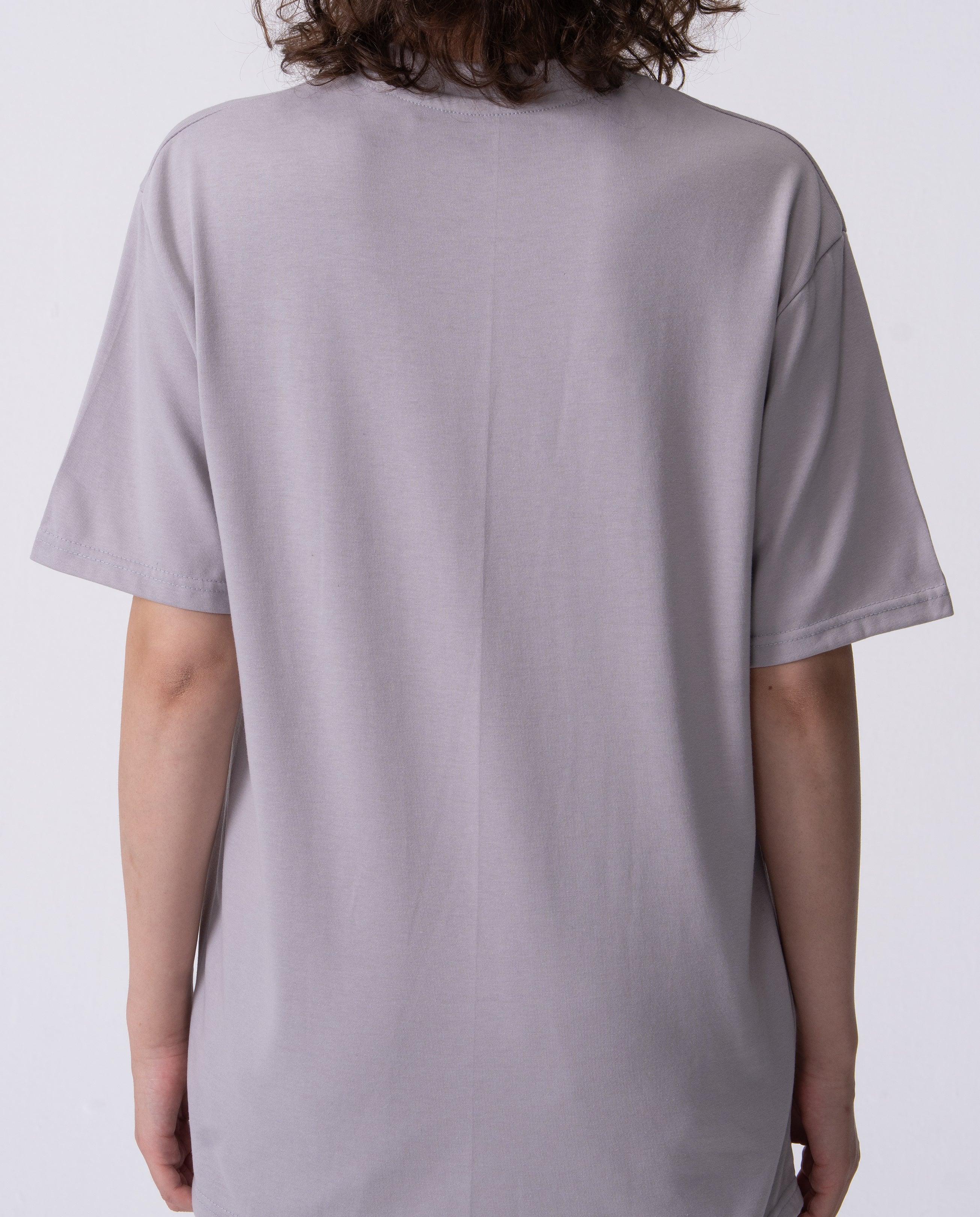 Person wearing a plain gray t-shirt on a white background