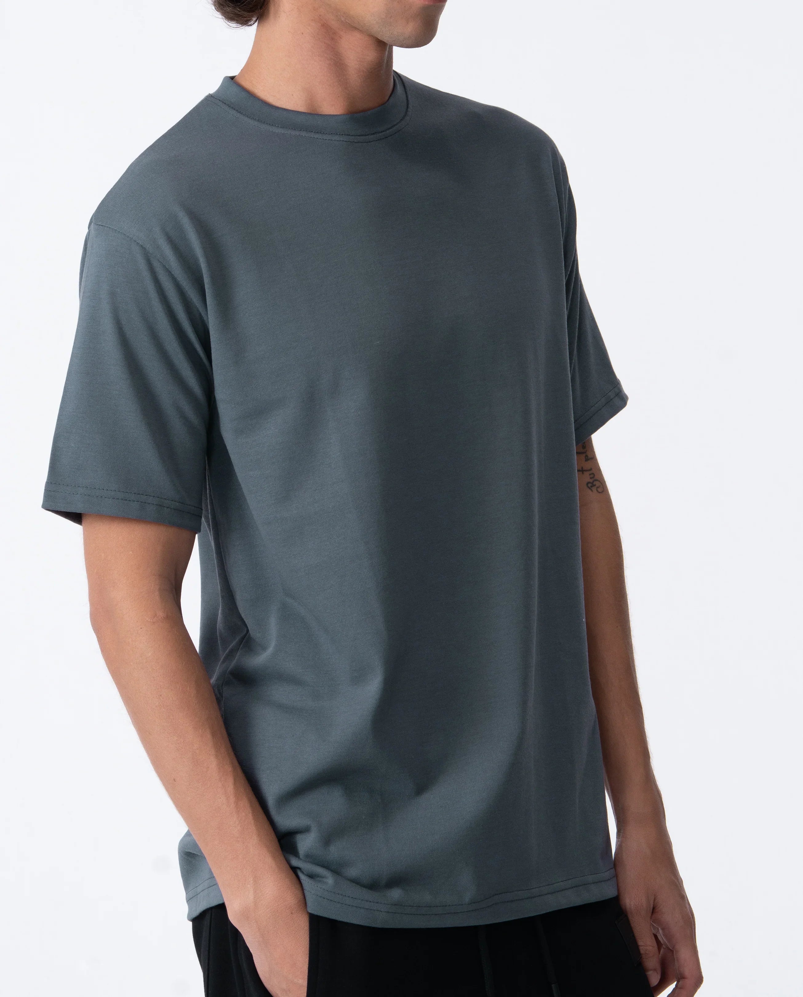 Person wearing a plain dark gray t-shirt on a white background