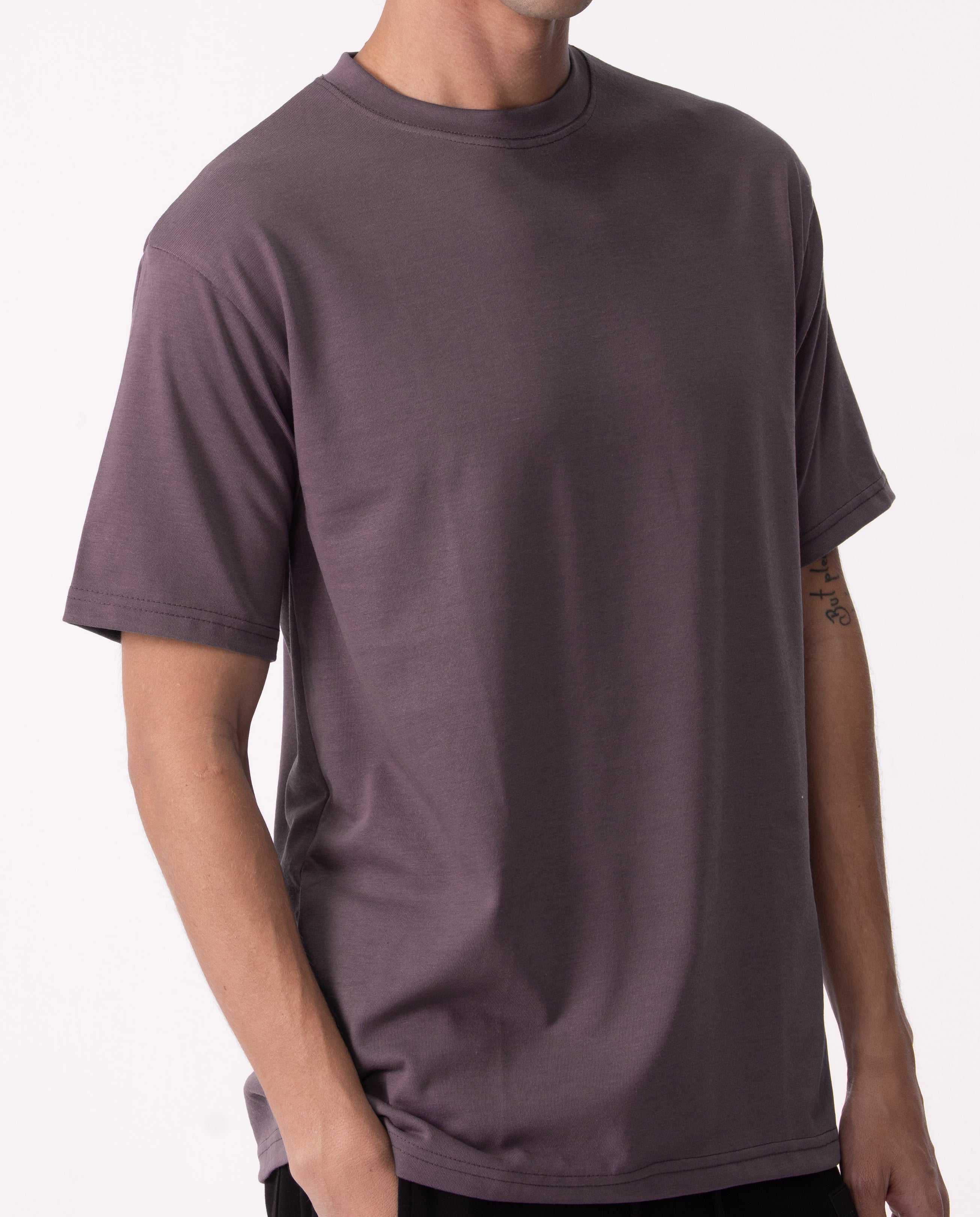 Person wearing a plain purple t-shirt on a white background