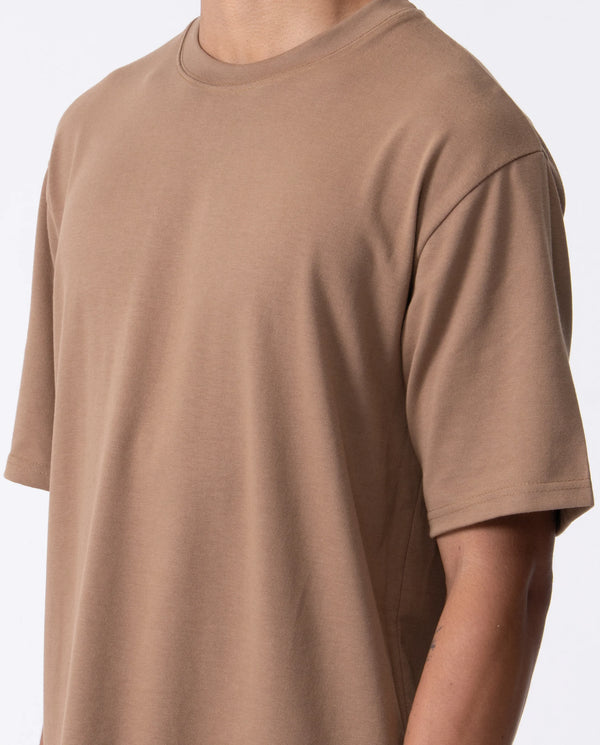 Brown t-shirt worn by a person on a white background