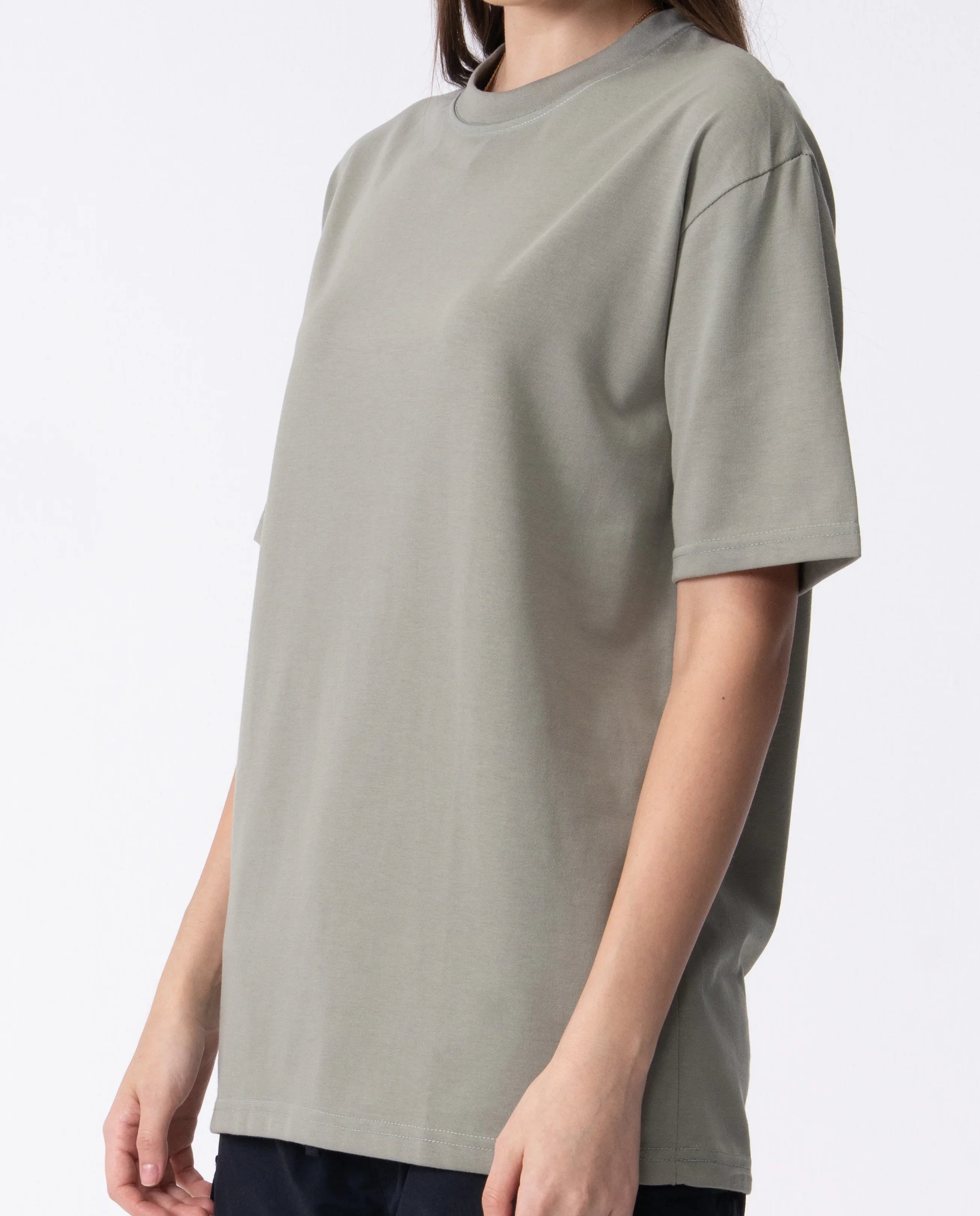 Person wearing a plain gray t-shirt on a white background