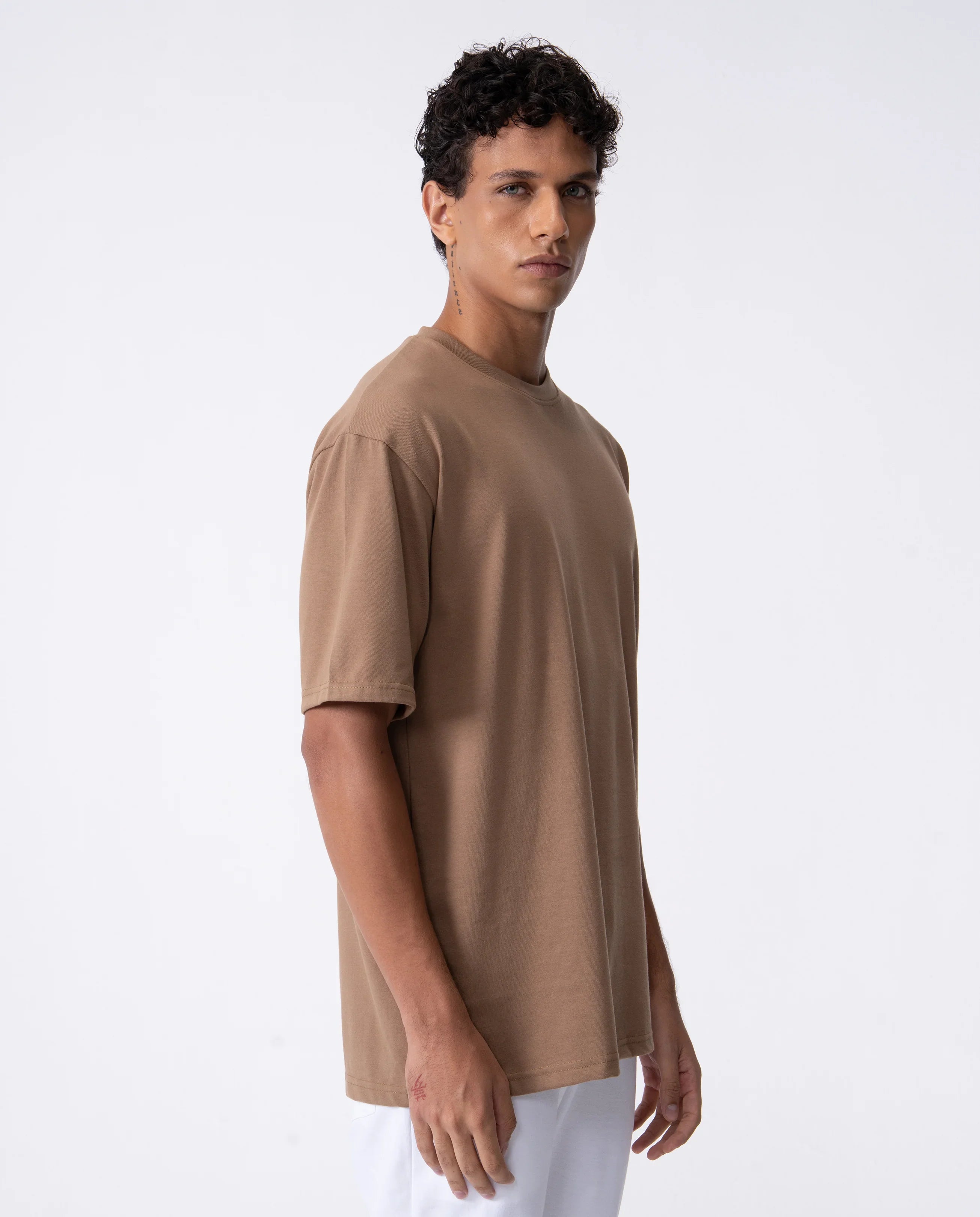 Man wearing a beige t-shirt on a white background