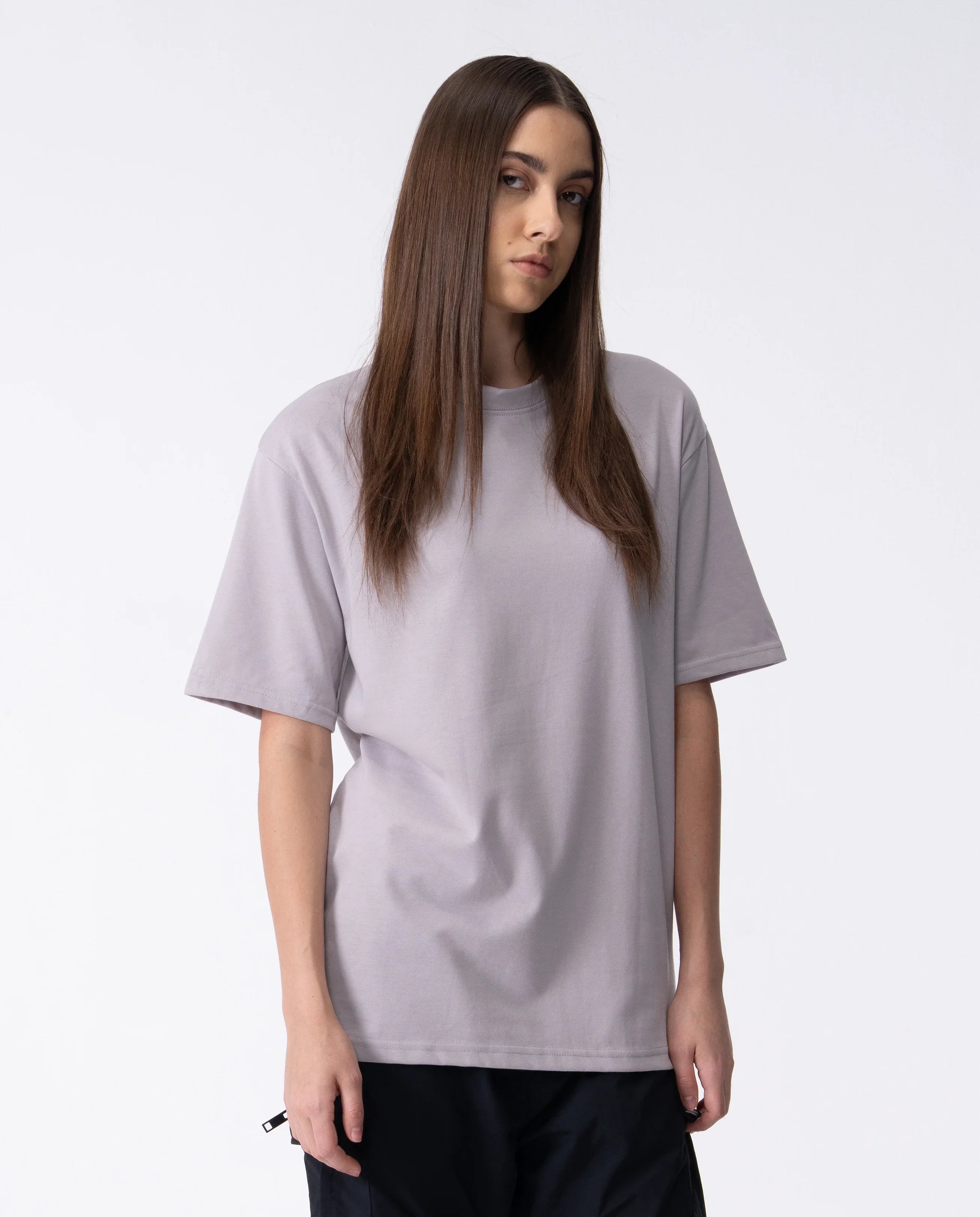 Person wearing a plain light gray t-shirt on a white background