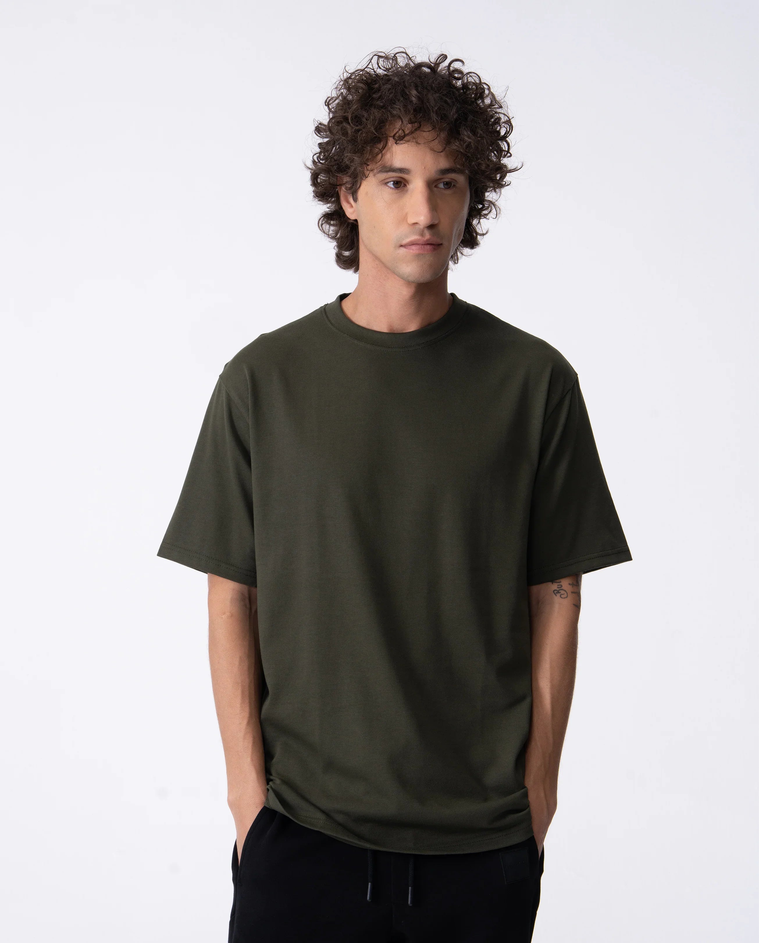 Man wearing a dark green t-shirt against a white background