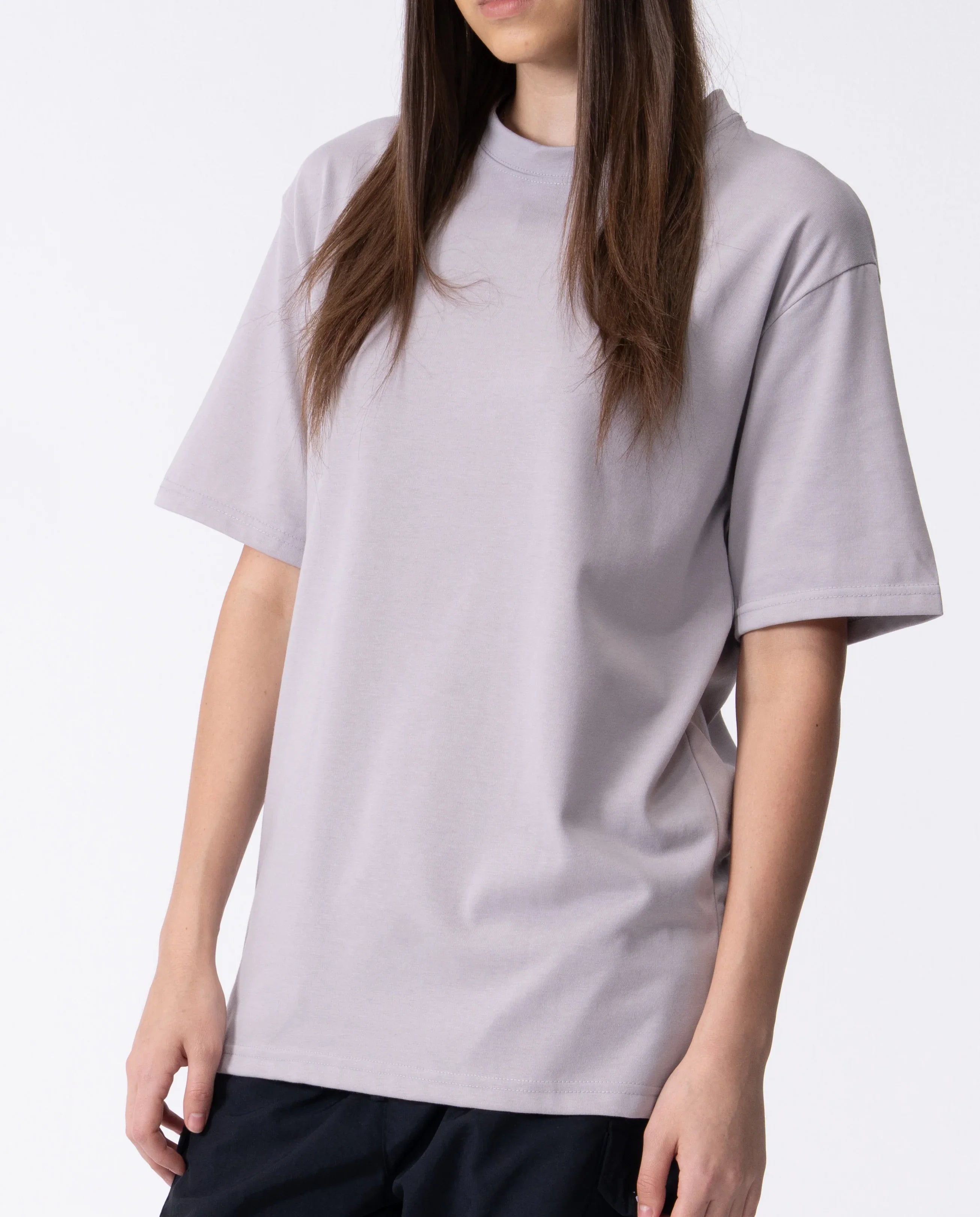 Person wearing a plain light gray t-shirt on a white background