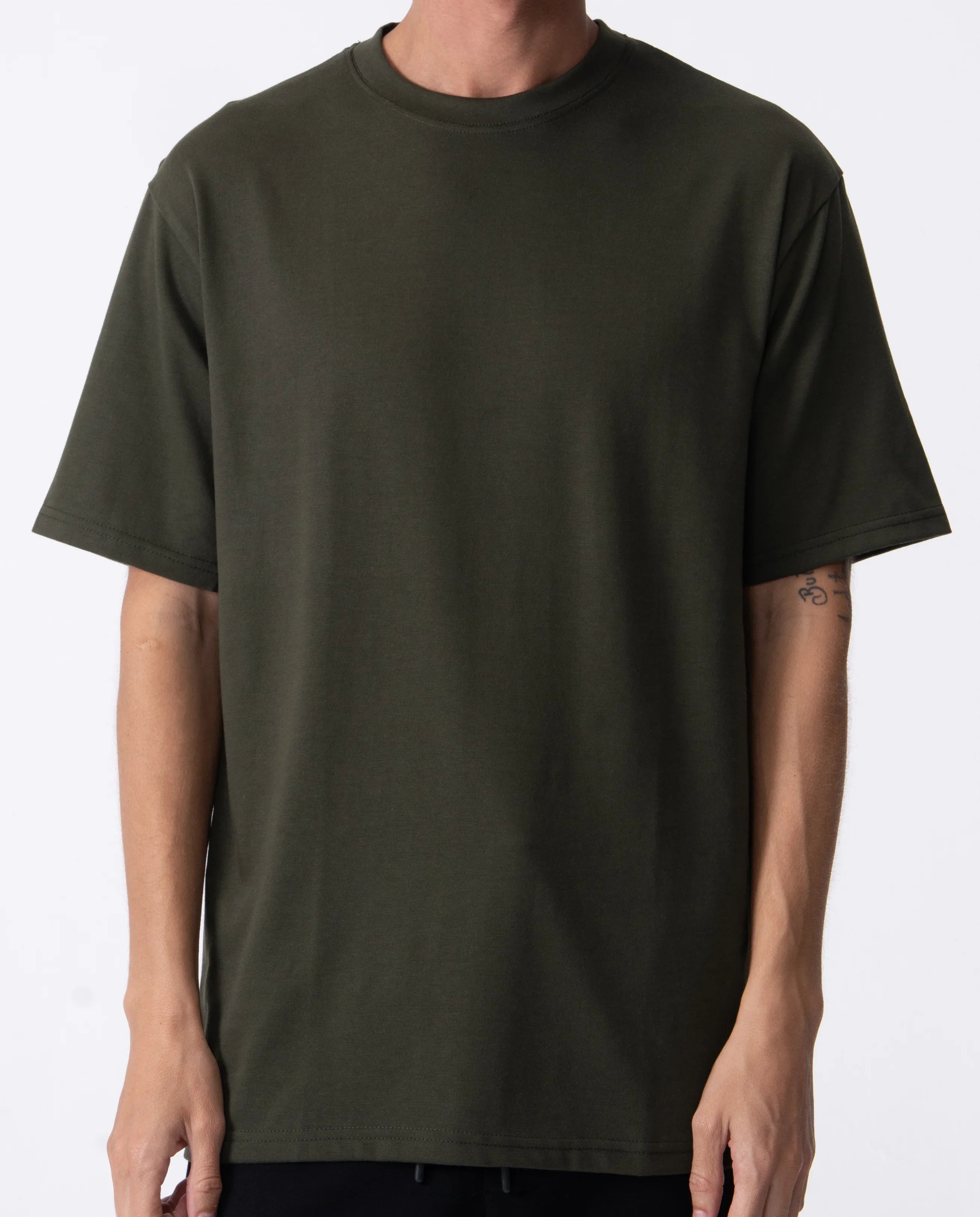 Person wearing a plain green t-shirt on a white background