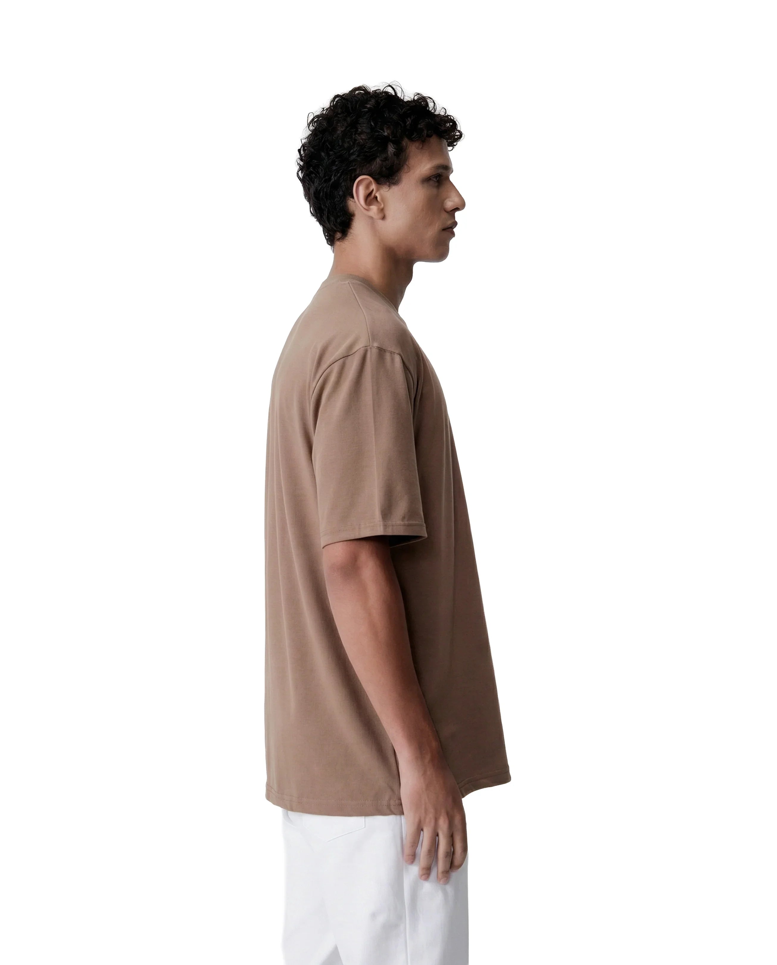 Person wearing a brown t-shirt and white pants on a white background