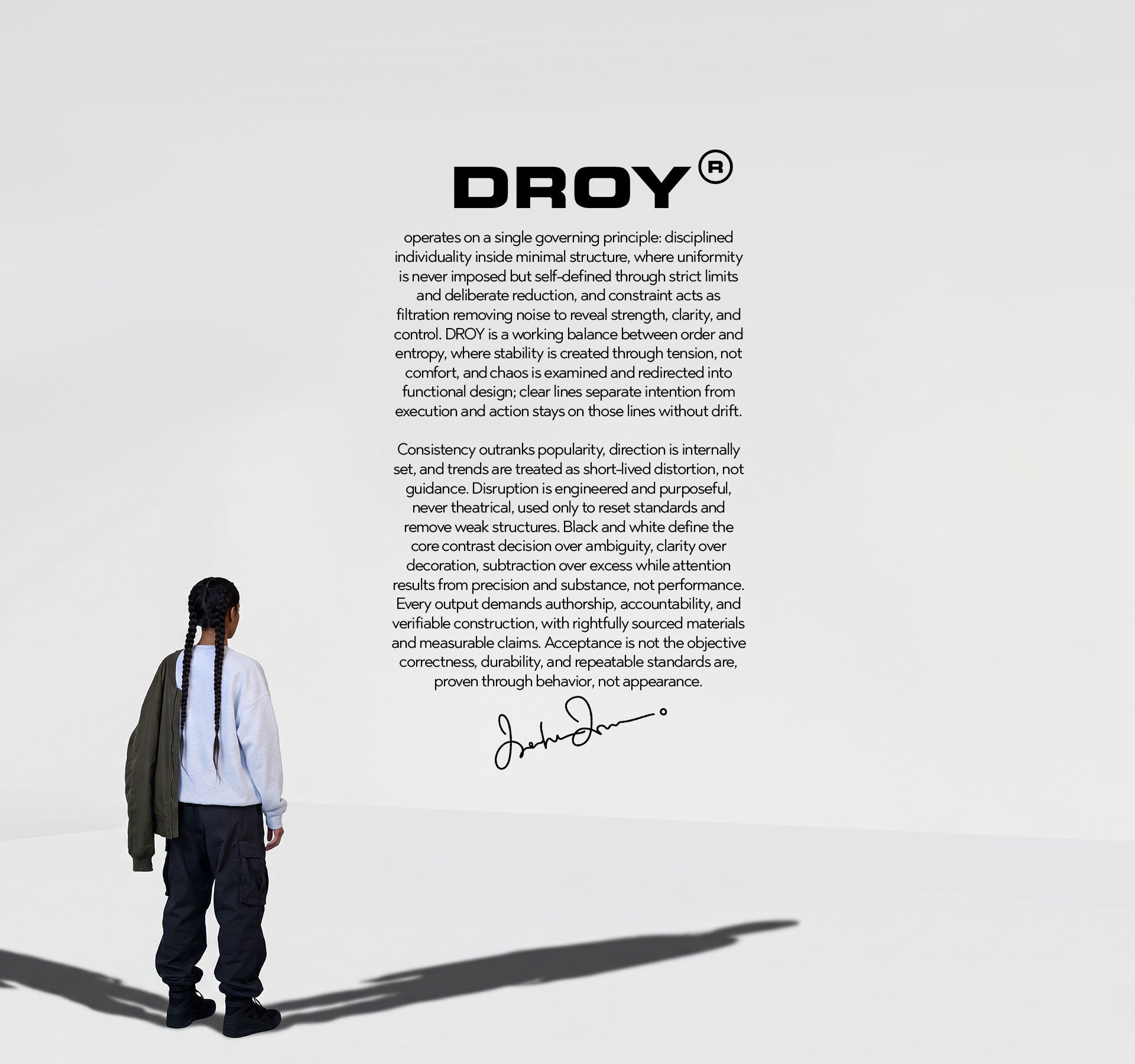 Person standing with a white background and 'DROY' branding text.