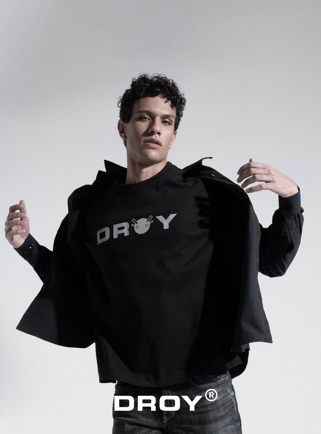 Person wearing a black hoodie with 'DROY' branding on a gray background