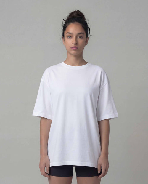 Person wearing a plain white t-shirt against a neutral background
